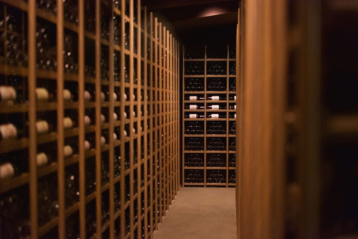 Rows of wine bottles resting on shelves in a wine cellar