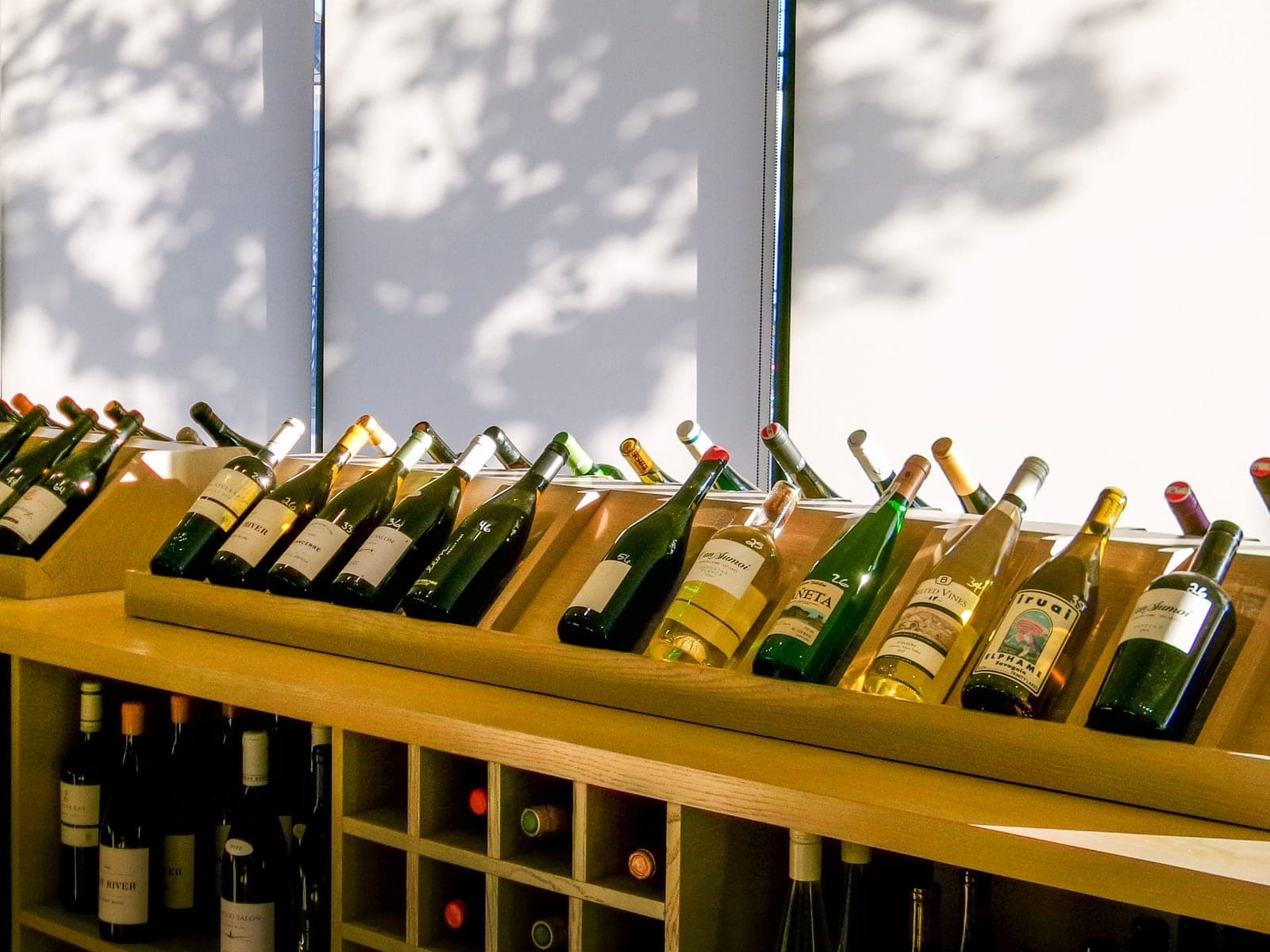 Wine bottles resting on wooden racks in a cellar